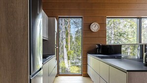 Una cocina moderna con paredes de madera, un ventanal grande y un reloj en la pared.