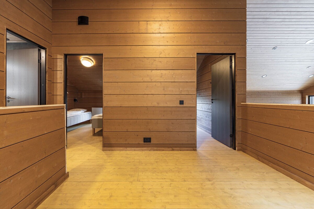 Un couloir aux murs lambrés et au plancher en bois.