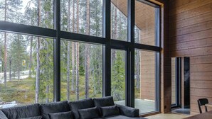Un interior moderno con ventanas amplias, un sofá modular y una pared de madera.
