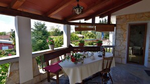 An outdoor patio with a table set for dining, surrounded by stone walls and wooden beams. - Wonderful terrace retreat (Savudrija)
