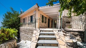 A stone house with a stone staircase leading to a porch. - Almondtree House Exanthia - Private Parking (Lefkada)