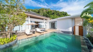 A modern house with a clear swimming pool, outdoor seating, and lush greenery. - Étoile Kata Luxury Pool Villas by Astra (Karon)