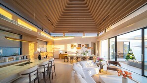 A modern interior with a kitchen, dining area, and seating space. - Étoile Kata Luxury Pool Villas by Astra (Karon)