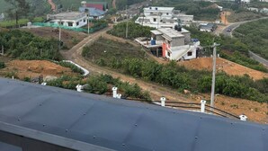 Paisaje rural con campos en terrazas, un camino serpenteante y varias construcciones con techos planos.