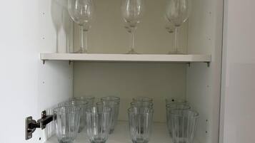 Ein Schrank mit zwei Einlegeböcken; der obere Boden enthält drei Weingläser, und der untere Boden sechs klare Gläser.