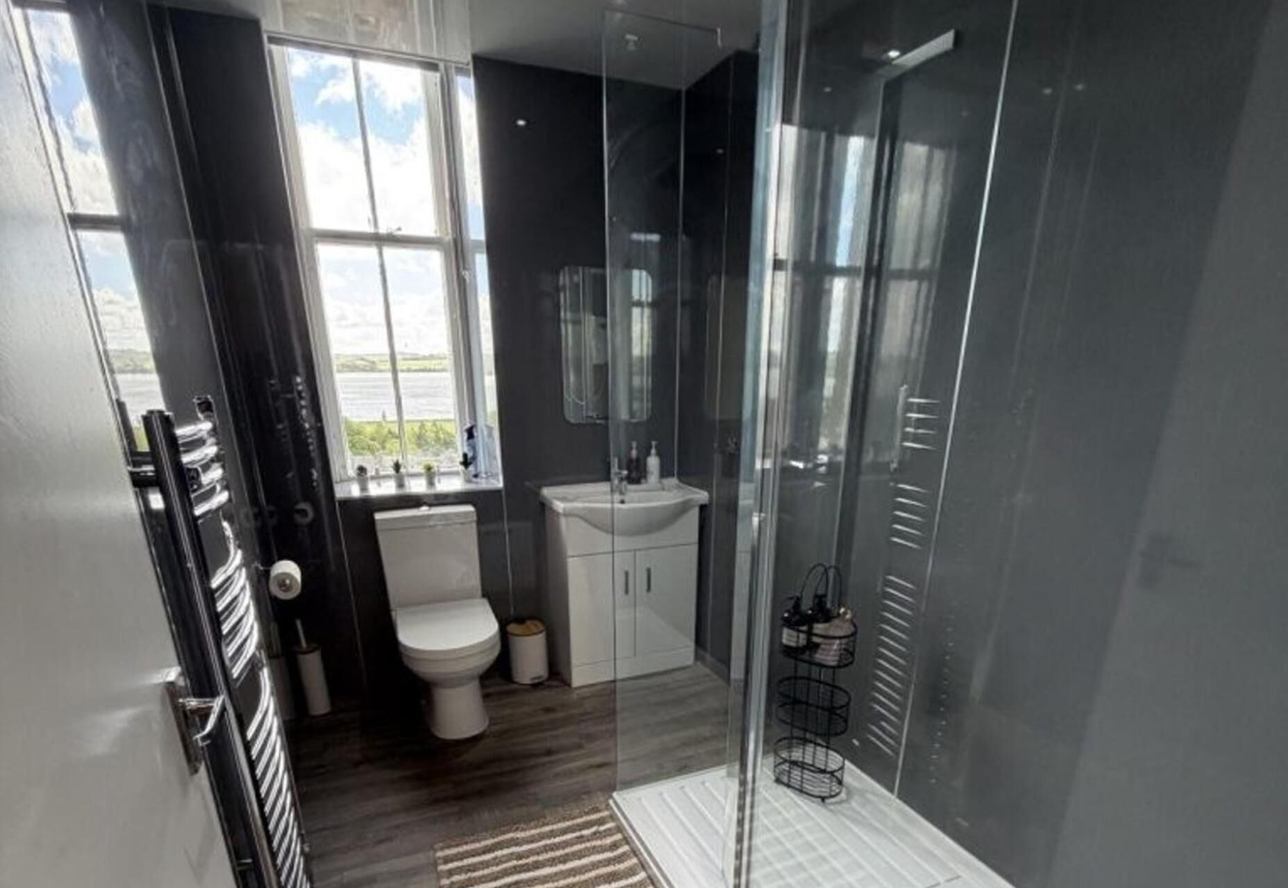 A modern bathroom with a toilet, sink, and shower area.
