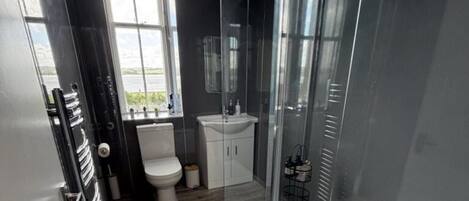 A modern bathroom with a toilet, sink, and shower area.