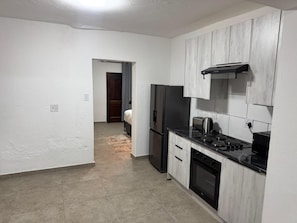 A kitchen with white cabinets, a refrigerator, a stove, and a microwave. - Boutique Hotel-Style 8Bed Villa Ferndale (Randburg)