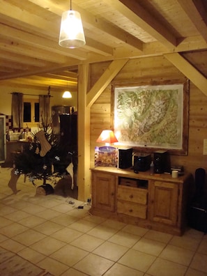 A wooden interior with a dining table, chairs, a hanging light fixture, and a framed map on the wall. - Family chalet facing Mont Blanc (Saint-Gervais-les-Bains)