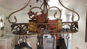 A kitchen with a hanging pot rack, a stove, and a sink. - Long Term- Monthly/Yearly (Bradford)