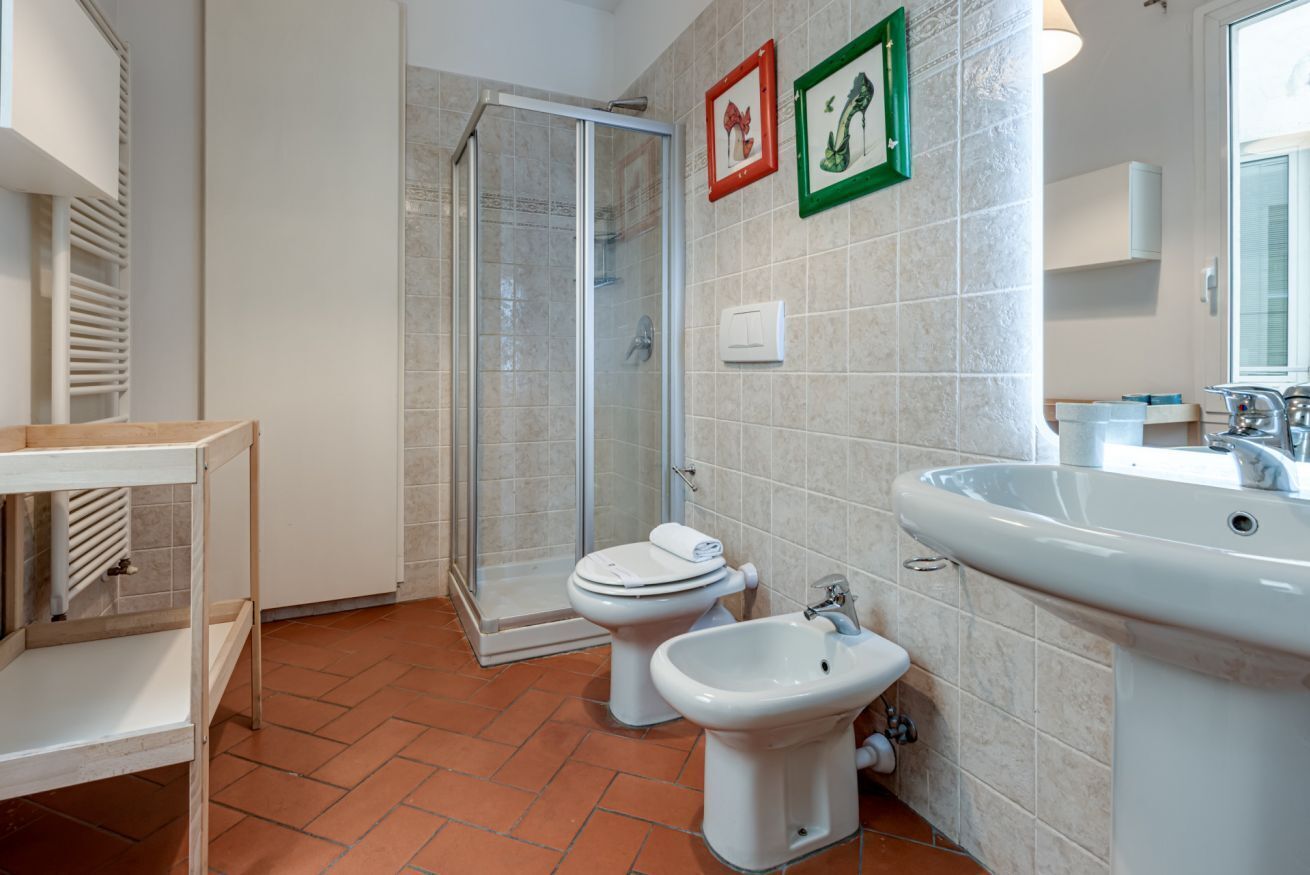 Ein Badezimmer mit Dusche, Toilette, Bidet und Waschbecken.