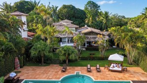 A villa with a swimming pool, outdoor seating, and lush greenery. - Azorai Hotel Boutique (Santa Cruz Cabrália)