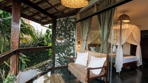 A room with a glass table, a woven chair, a bed with a canopy, and a sign reading 'Palmvine Suite.' - Azorai Hotel Boutique (Santa Cruz Cabrália)