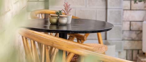 A round table with chairs, a stone archway, and potted plants.