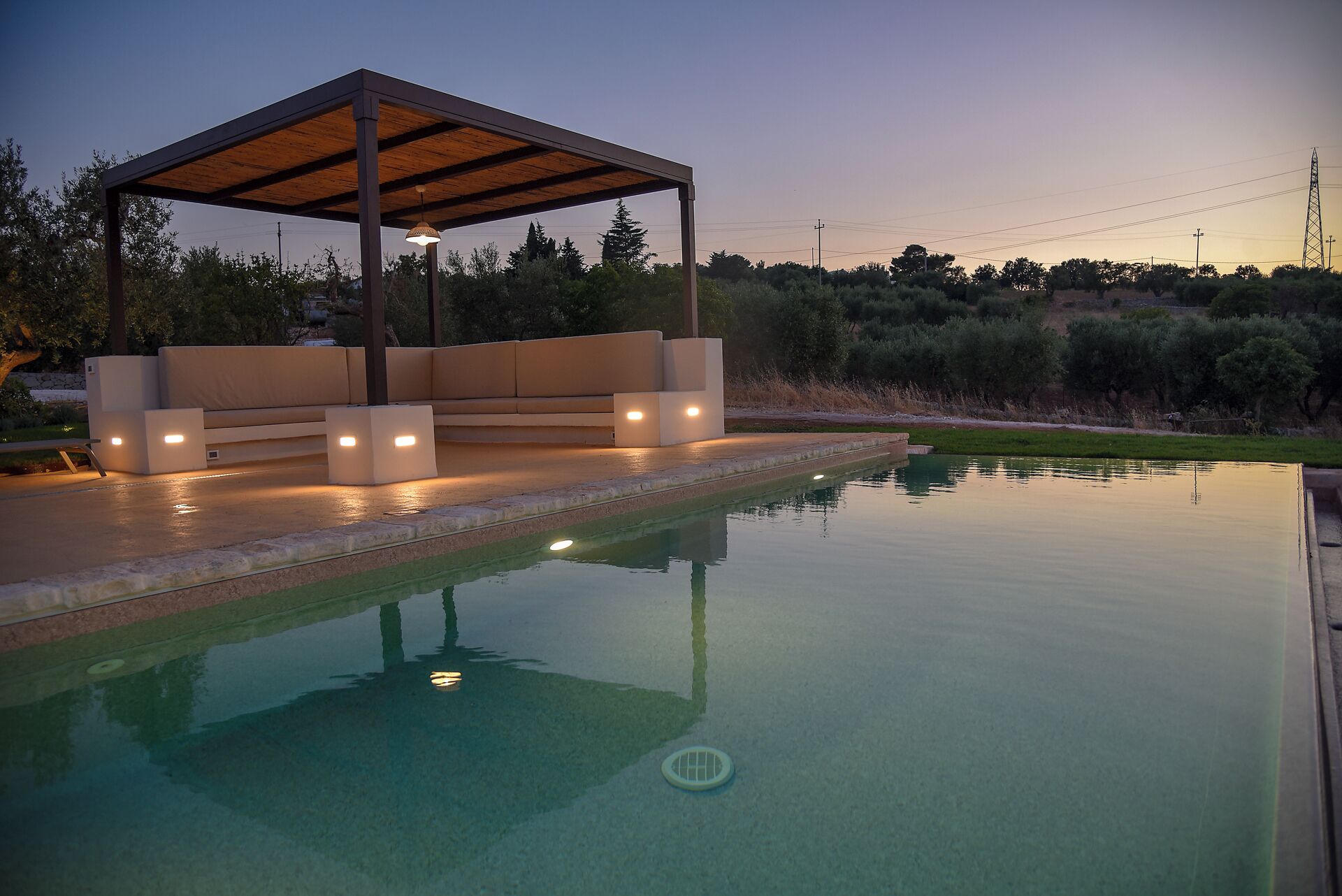 A poolside area with a covered seating area and a pool.