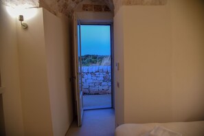 A narrow hallway leading to a stone wall outside. - TD Trullo Rosmarini Enchanted Retreat With Pool (Cisternino)