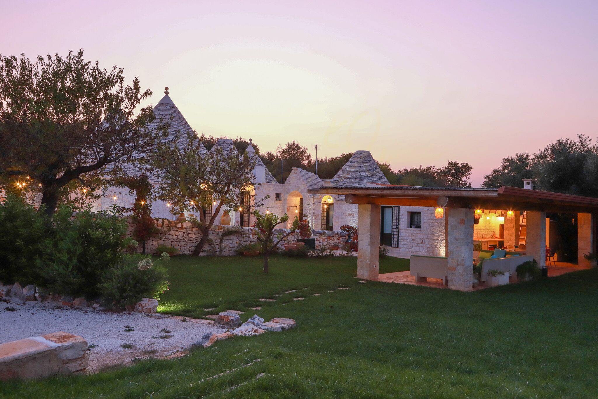 A stone house with a garden and outdoor seating area.
