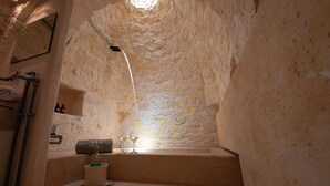 A narrow, stone-walled interior with a small sink, a towel, and two glasses on a ledge. - TD Casale Belladinotte Poolside Country Bliss (Ceglie Messapica)