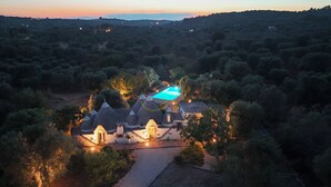 Una proprietà rurale con diversi edifici, una piscina e un giardino curato.