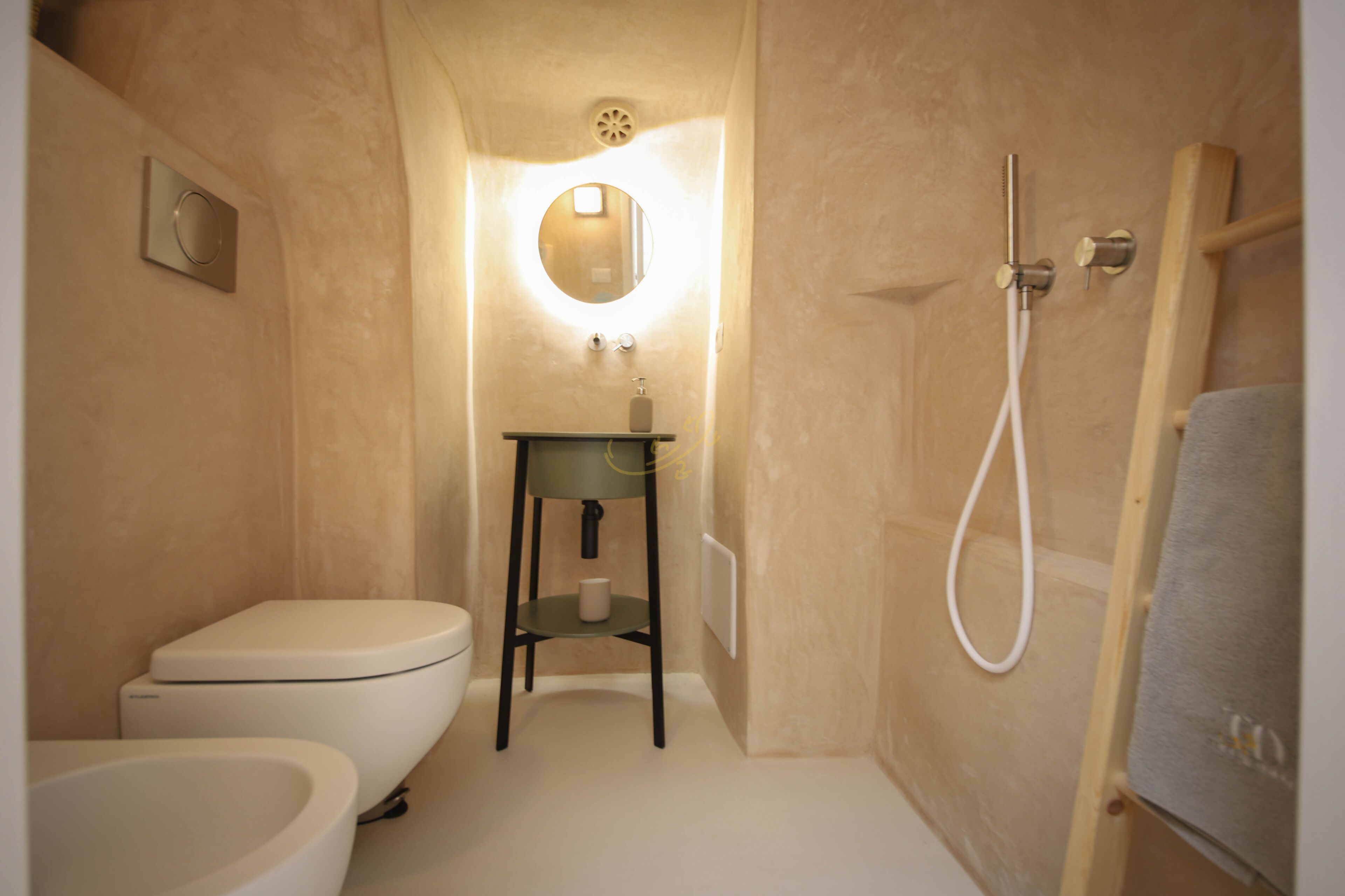 Une petite salle de bain comprenant des toilettes, un lavabo et une douche.