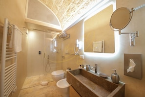 Ein modernes Badezimmer mit Dusche, Toilette, Waschbecken und Spiegel.