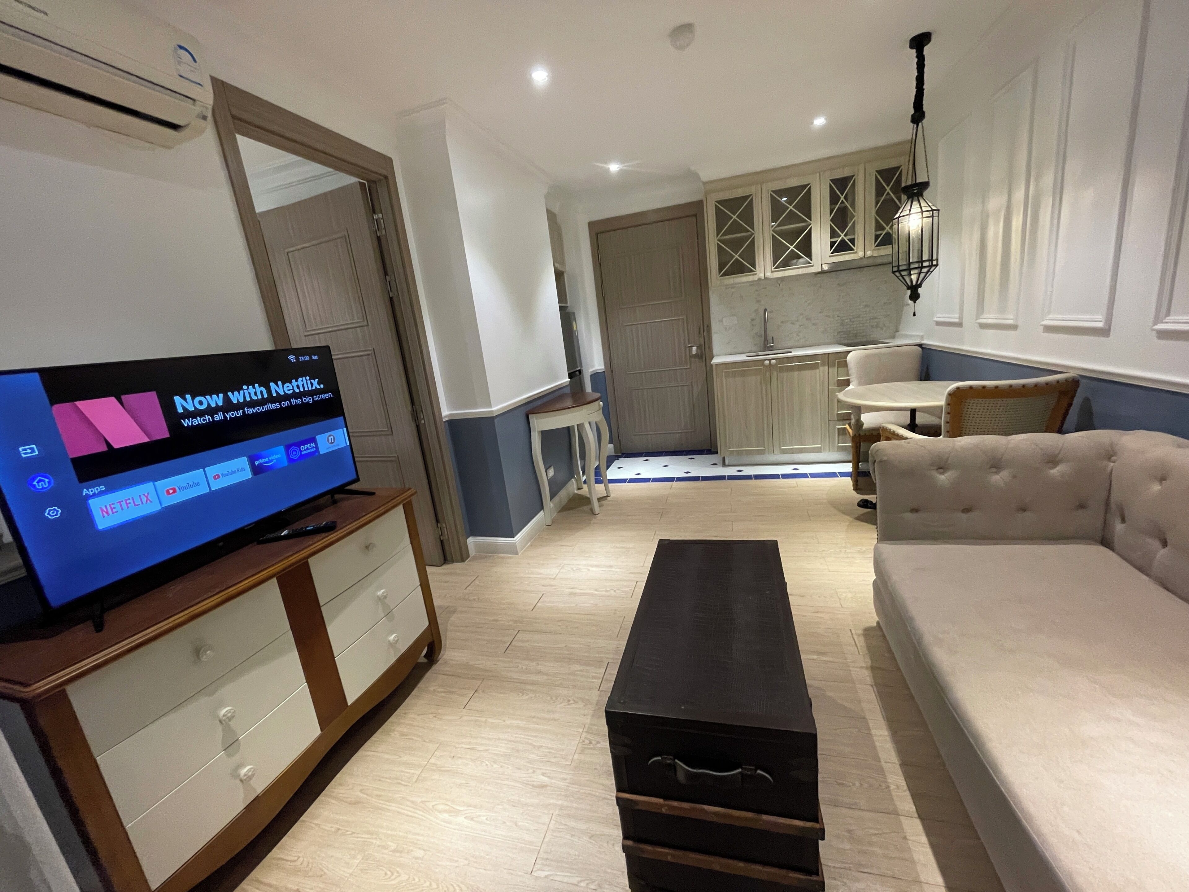 A living room with a TV, sofa, and a small table.