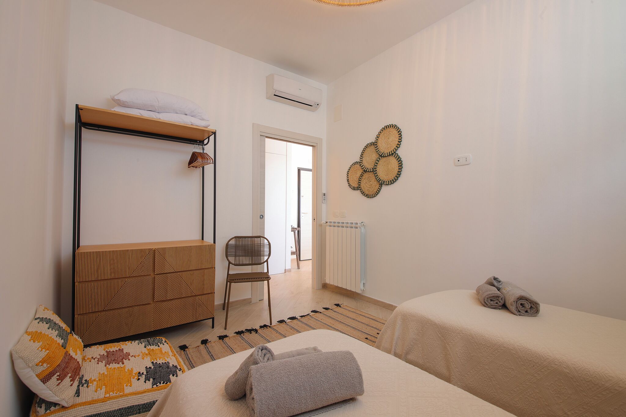 Une chambre avec un lit superposé, une chaise, un radiateur et des serviettes sur le lit.