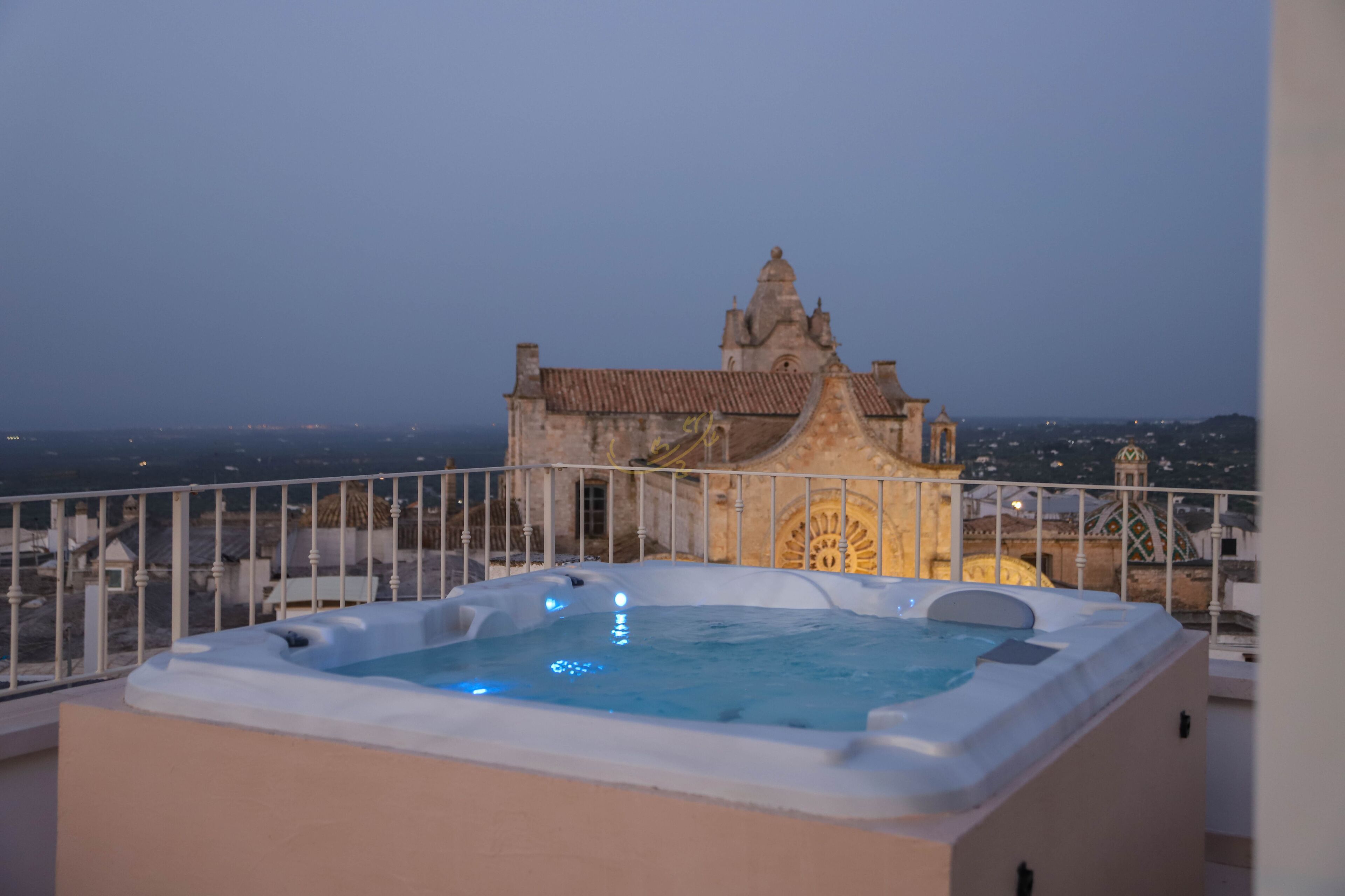 A hot tub on a balcony with a view of a historic building.