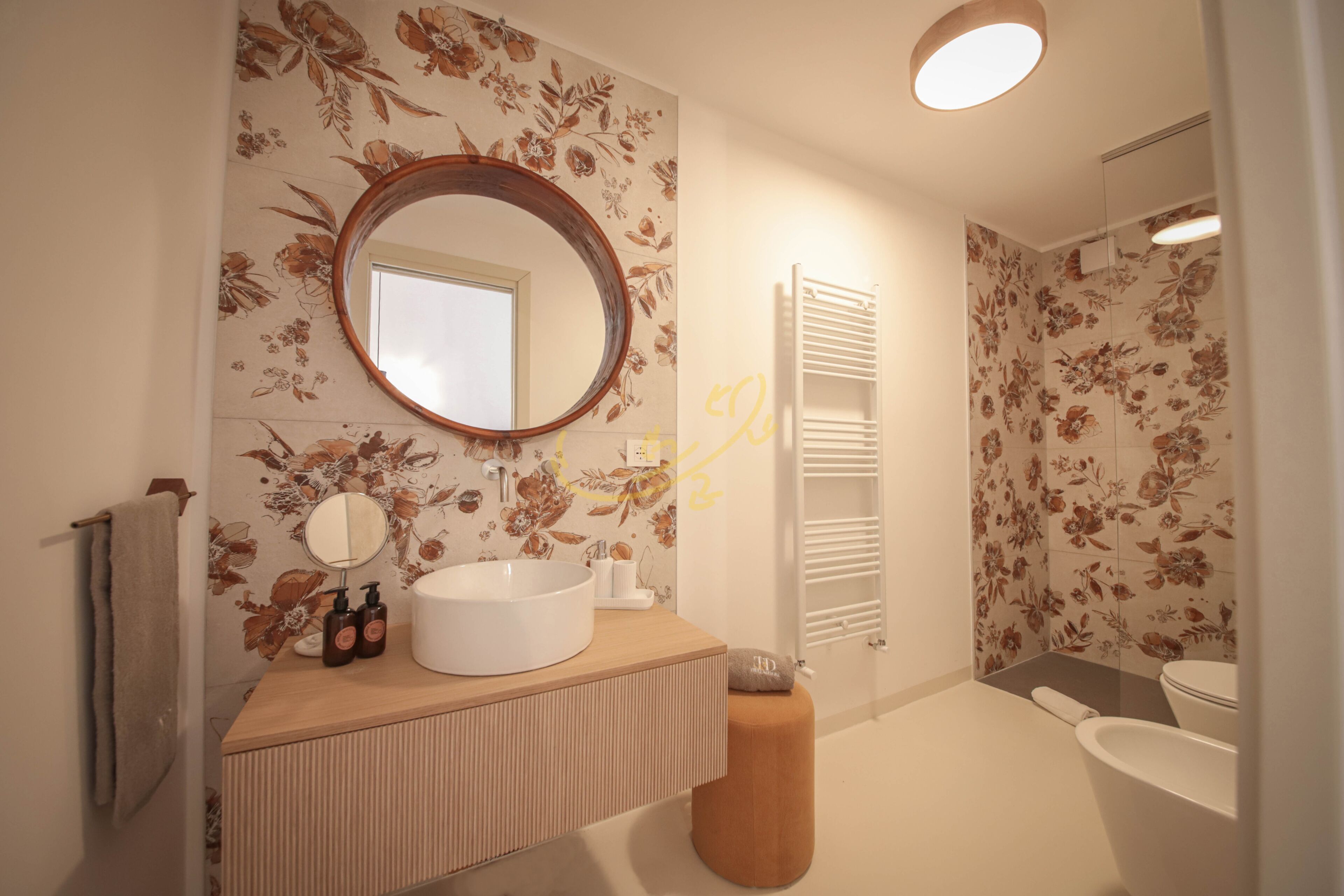 Ein modernes Badezimmer mit einem Holz-Waschtisch, einem runden Spiegel und einer großen Badewanne.