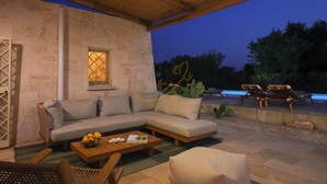 An outdoor seating area with a sofa, chairs, and a table. - TD Trullo Titiro Vineyard, Wine Cellar & Pool (Ostuni)