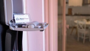 A hotel reception desk with a sign that reads 'Here & There Properties.'