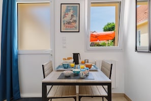 Una preparación para el desayuno con una mesa, sillas y vistas por la ventana.
