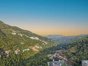 A mountainous landscape with residential buildings and a large estate with multiple towers.