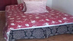 Un lit avec une couvre-lit à motifs floraux et un oreiller assorti.