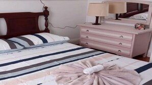 Une chambre à coucher avec un lit, une commode, un miroir et une lampe.
