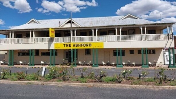 Un immeuble de deux étages doté d’un balcon et d’une enseigne sur laquelle on peut lire « The Ashford ».