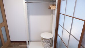 A room with a wardrobe, a small round trash bin, and a wooden door. - Compact Easy Stay - Budget Nakasu (Fukuoka)