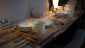A kitchen counter with a microwave, a white vase, and a table lamp. - Compact Easy Stay - Budget Nakasu (Fukuoka)