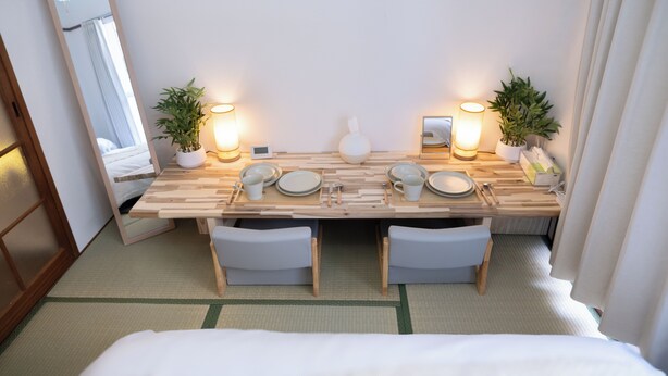 A neatly arranged dining area with a wooden table, chairs, and a mirror. - Compact Easy Stay - Budget Nakasu (Fukuoka)