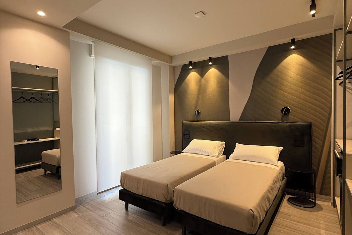Un dormitorio moderno con una cama grande, un vestidor y un espejo.