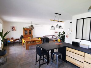 Eine moderne Küche mit Essbereich, einer Couch und einem großen Fenster.