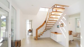 Ein modernes Interieur mit einer Holztreppe, einem Essbereich und einer Küche.