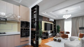 Una sala de estar moderna con un televisor de pantalla plana, un sofá y una mesa de centro.