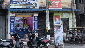 A multi-story building with signage for 'E-Corner' and 'E-Guest House' offering services like air tickets and holiday packages. - Balaji Guest House (Guwahati)