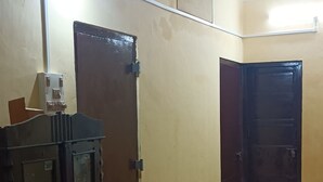 A room with a table, a cabinet, and two doors. - Balaji Guest House (Guwahati)