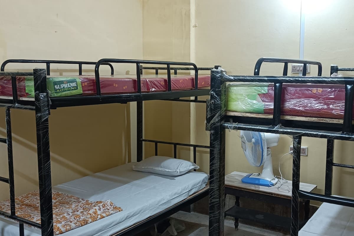 A bunk bed room with a fan and a small table.