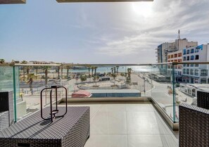 Ein Balkon mit Blick auf Strand und Gebäude.