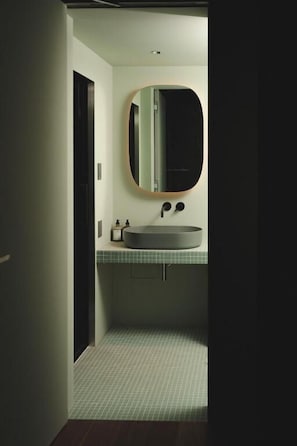 A bathroom with a round mirror, a sink, and a tiled floor. - MU HEN KO Tokyo (Tokyo)