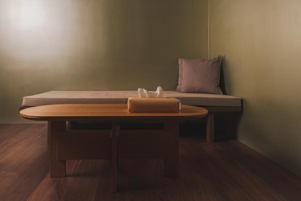A room with a wooden table and a cushioned bench against a wall.