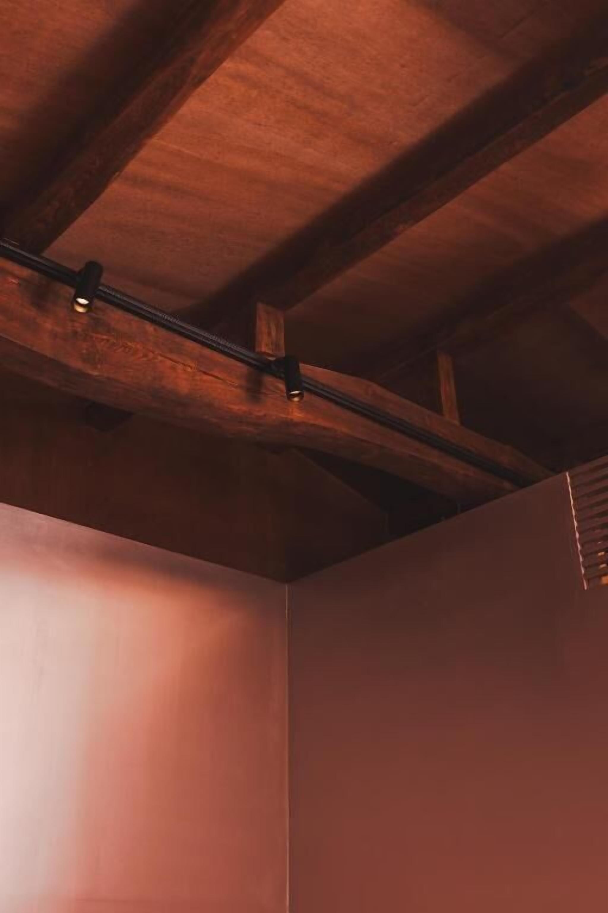 A room with exposed wooden beams and a sloped ceiling.